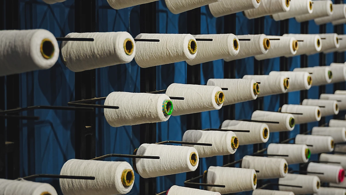 Rows of white yarn cones with coloured tips mounted on a blue industrial creel